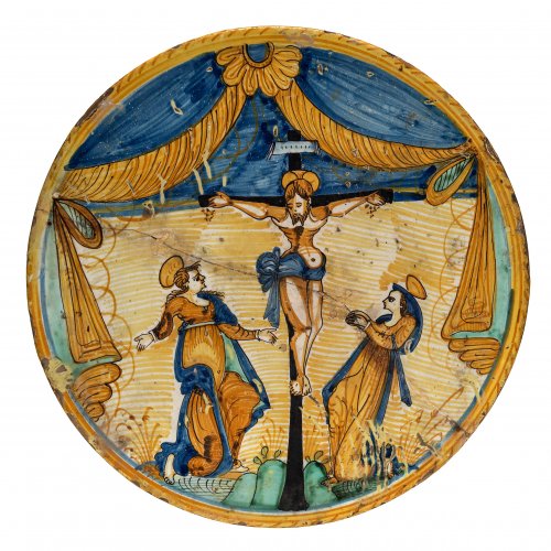 Platte. Majolika, farbige Malerei. Christus am Kreuz unter Vorhangdraperie. Deruta oder Montelupo, 16./ 17. Jh. ø40 cm.
