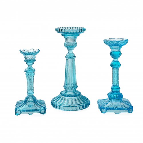 Drei Kerzenleuchter. Türkisblaues Pressglas. Bayerischer Wald. Unterschiedlicher Ornamentdekor. H. 16,5-22 cm.