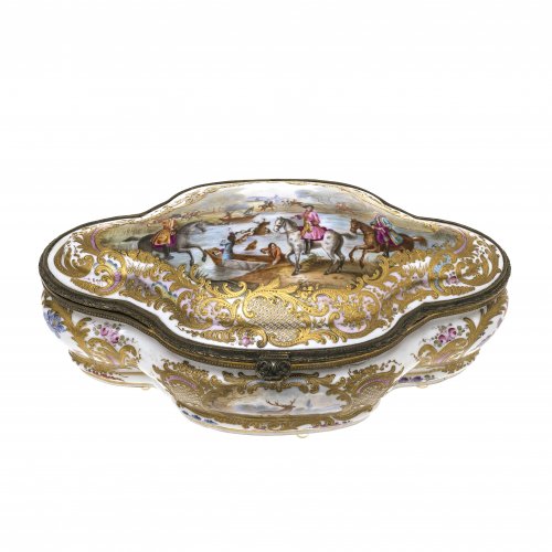 Schmuckdose, Frankreich, 19. Jh.
Im Stil des Rokoko. Jagdszenen, umgeben von buntem Blumendekor und goldener Rankenornamentik. Messingbeschläge. 13,5 x 32 x 18 cm. Best., Risse.