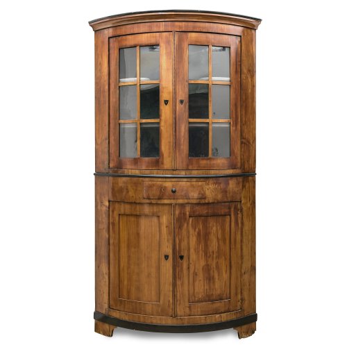 Vitrineneckschrank. Rheinland, um 1830. Kirschbaum, furniert. H. 223 cm, Schenkeltiefe 80 cm. Kleine Furnierschäden.