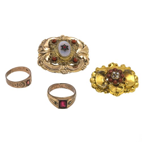 Zwei Broschen, zwei Ringe. Schaumgold, Korallen-, Granat- bzw. Glassteinbesatz. Tw. besch., ein Ring rep.