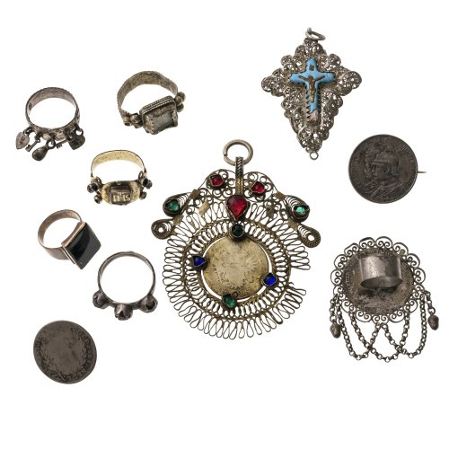 Konvolut Trachtenschmuck, 10-teilig (5 Ringe, 1 Münze als Knopf, 1 Münze als Brosche, 2 Anhänger, 1 Miedergeschnüranhänger). Tw. besch.