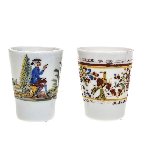 Zwei kleine Becher. 19. Jh. Weißes Milchglas mit farbiger figürlicher und vegetativer Emailmalerei.  H. 10  cm. Farbabrieb.