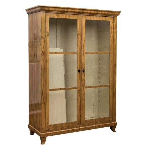Vitrinenschrank. Deutsch, 19. Jh. Kirschbaum furniert. Zweitürig, frontal verglast. Fünf Einlegefächer. Alterungsspuren. 178 x 117 x 50,5 cm. Mit Schlüssel.