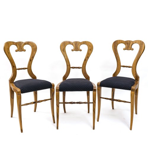 Drei Stühle. Schaufellehne. Nussbaum furniert. H. ca. 94 cm, Sitzhöhe 50 cm.