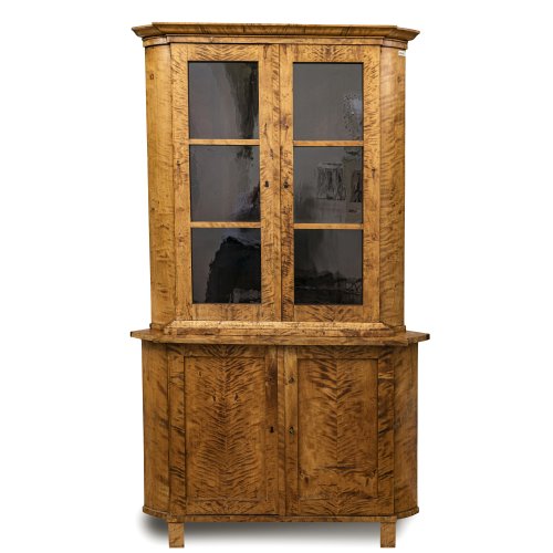Eckvitrine. Österreich, 19. Jh. Birke geflammt. H. 198,5 cm. Breite 118 cm, Schenkeltiefe 82 cm.