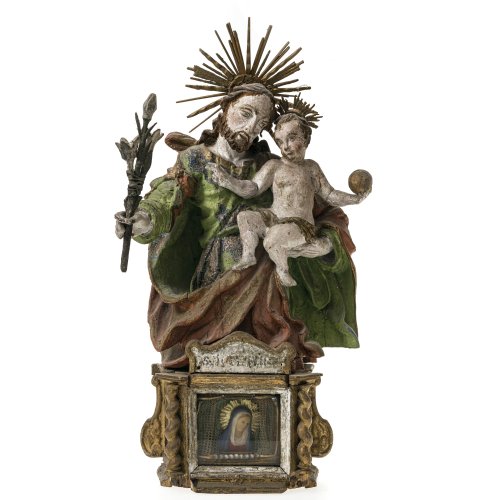 Hl. Josef mit dem Jesuskind. Holz, übergangene Farbfassung, im Sockel Mariengnadenbild aus Wachs. Alpenländisch. Besch., kleine Leistenteile fehlen, rest. H. 61 cm.