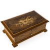 Musikspieldose. Reuge Music. Wurzelholzfurnier, Deckel mit Bouquet aus Musikinstrumenten. 9,5 x 28,5 x 17,5 cm.
