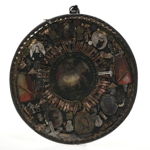 Altbayern, 18. Jh. Wettersegen. Rund. 22,5 cm. Achsensymmetrisch und kreisförmig um zentrales Wachsmedaillon (Lamm Gottes) angeordnete Reliquienpartikel. Medaillons teilw. besch., Alterungsspuren. ø 22,5 cm.