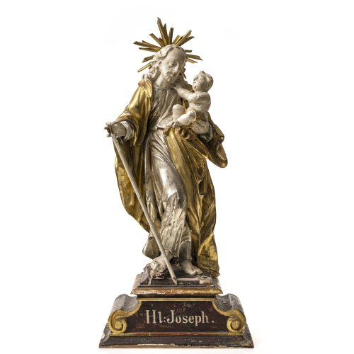 Hl. Joseph. Holz, übergangene Inkarnat-, Gold- und Silberfassung. Besch., ein Finger und Stabbekrönung fehlen, Strahlenkranz erg. H. 61 cm.