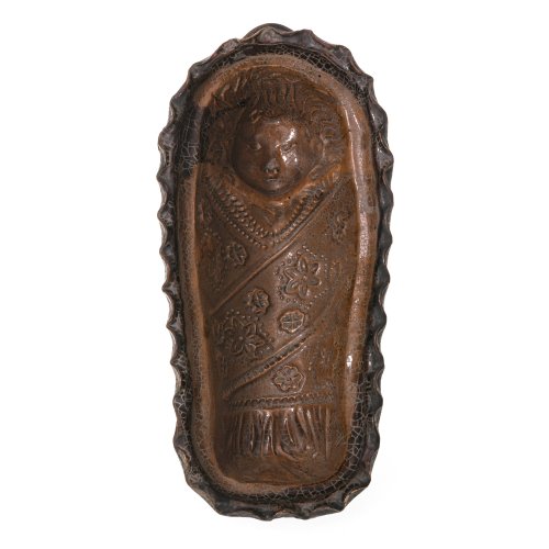 Fatschenkind-Backform. 19. Jh. Hafnerkeramik. Ockerfarben glasiert. Auf drei Füßen. L. 30 cm. Alterungsspuren.