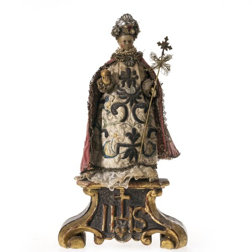 Prager Jesuskind. Wachs, textile Bekleidung, auf Volutensockel. Besch. H. 31 cm.