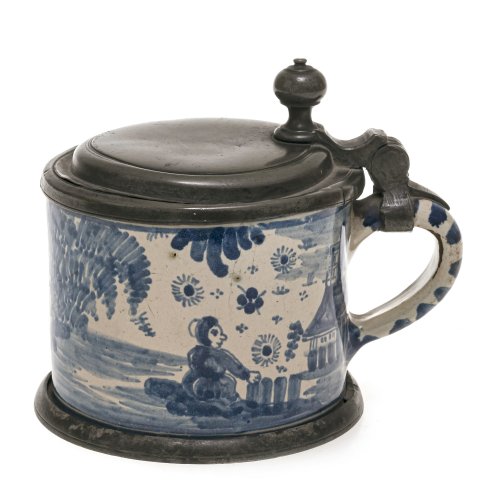 Kleiner Deckelkrug. Fayence, Blaumalerei, Zinnmontierung. Besch., Haarrisse. H. 11 cm.