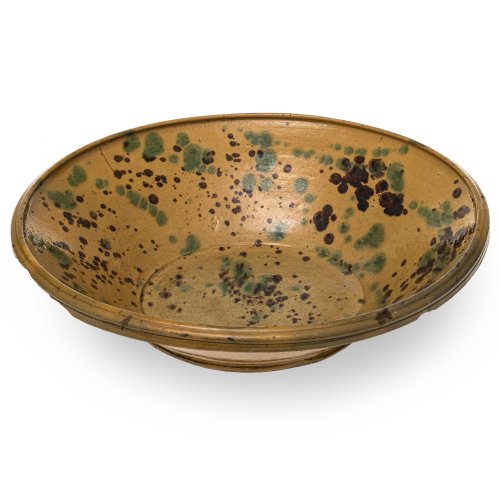 Tiefe Schüssel. Irdenware, ockerfarben glasiert, Spritzdekor in Braun und Grün. Rand unterseitig mehrfach best. ø 42 cm.