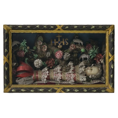 Fatschenkindl im Schrein. Süddeutsch. Wachs, textile Bekleidung. Alterungsspuren, leicht besch. 26 x 42 x 16 cm.