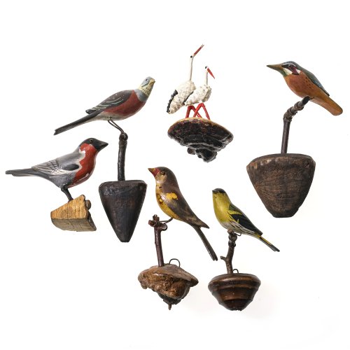 Sechs Vögel. Alpenländisch, 19. Jh. Vögel aus Holz (außer Storchenpaar), farbig gefasst. Auf Astgabel oder Holzschwamm sitzend. Diverse Größen. Alterungsspuren, ein Augenpaar fehlt.