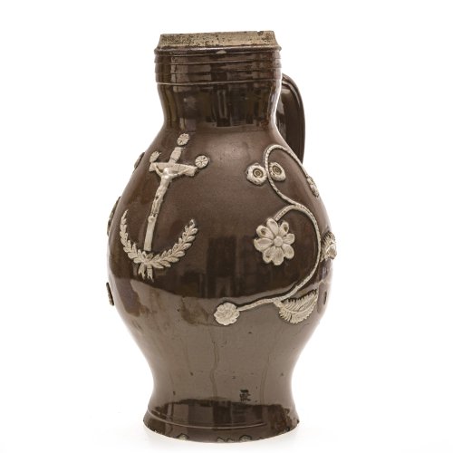 Großer Birnkrug. Bunzlau. Irdenware, mittelbraune Glasur, weißer Reliefdekor mit Kruzifix. Best. H. 33 cm.