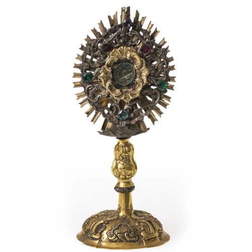 Reliquiar in Monstranzform. Metall, tw. versilbert, erneuerte Vergoldung, farbiger Glassteinbesatz. Verändert. H. 24 cm.