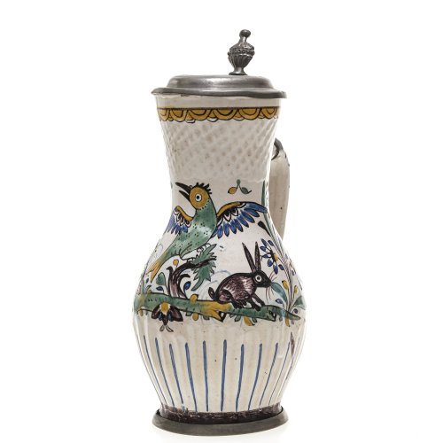 Niederösterreich, 2. H. 18. Jh. Birnkrug, Fayence. Hellbrauner Scherben, partiell geprägt und geritzt. Weiße Zinnglasur mit Scharffeuerbemalung. Zinnmontierung, teilw. ergänzt. H. 24 cm. Best.