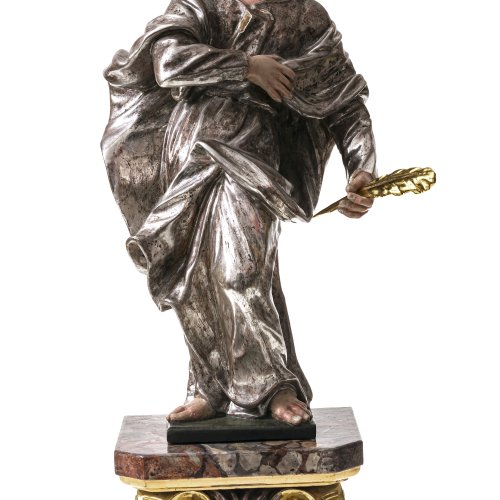 Süddt., 18./19. Jh. Holz, geschnitzt. Unbekannter Heiliger mit Schreibfeder auf Holzpodest mit Marmorimitation. Rücks. summarisch gearbeitet. Übergangene Farbfassung. Figur H. 46 cm, Podest 15,5 cm. Minim. best.