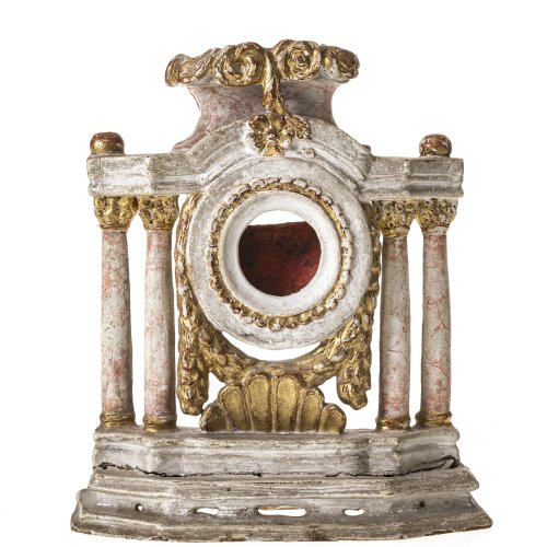 Taschenuhrenständer. Um 1800. Holz, Farbfassung, marmoriert. Architektonischer Aufbau mit Empirefeston. Besch., Riss, Bekrönung fehlt. H. 21 cm.