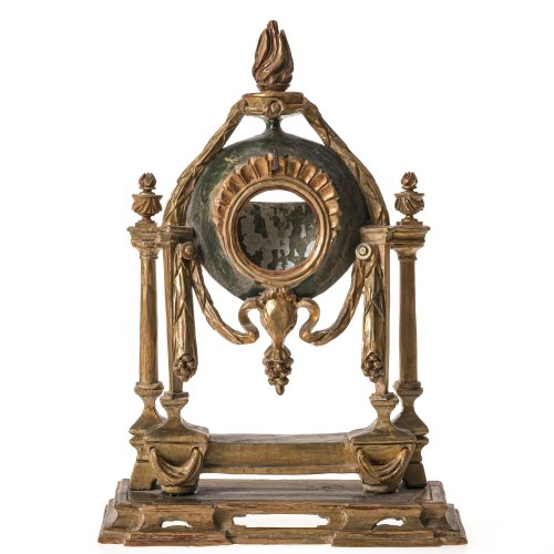 Taschenuhrenständer. Holz, geschnitzt, farbige und goldene Bemalung. Architektonischer Aufbau versehen mit Empirefestons. Minim. besch. H. ca. 31 cm.