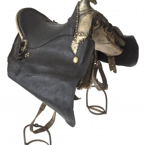 Sattel. Tirol, 19. Jh. Leder und Messingknauf in Pferdeform. Vermutlich zum Treideln verwendet.  L. 49 cm. Gebrauchsspuren.