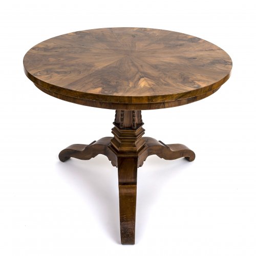 Runder Tisch. Deutsch, 1830/1840. Nussbaum, furniert. Dreiteiliger Fuß, gekanteter Schaft mit Perlstab.