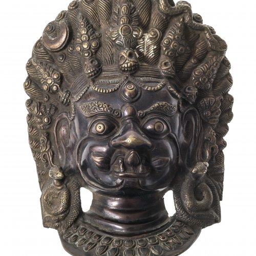 Maske des Yidam Bhairava. Nepal, um 1900. Im schreckerfüllendem Aspekt zur Vertreibung der Widersacher des Buddhismus. Bronze. H. 21 cm.