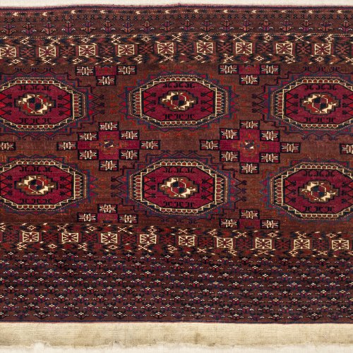 Teppichfragment. Tekke, Turkmenistan, 1. Drittel 20. Jh. Ohne Rückwand, auf Brett appliziert. 116 x 70 cm.
