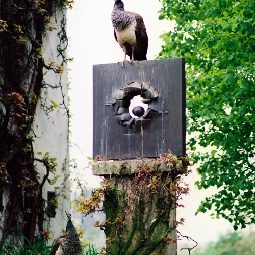 Hierl, Hubertus, Kranzvotiv I - Skulptur von Fritz Koenig auf dem Ganslberg. Ganslberg 1996. Farbfotografie. 40,5 x 30,5 cm. Unter Passepartout montiert. Rückseitig Fotografen-Copyright-Stempel, Negativ-Nr. 4029/18. Handschriftlich mit Bleistift dat.und bez., sign.