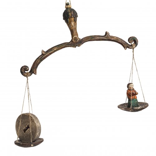 Seelenwaage. Süddeutsch, 19. Jh. Mit Seele und Mühlstein. Holz, farbig gefasst. Balkenlänge 35 cm. Höhe Schale mit Figur, ca. 8,5 cm.
