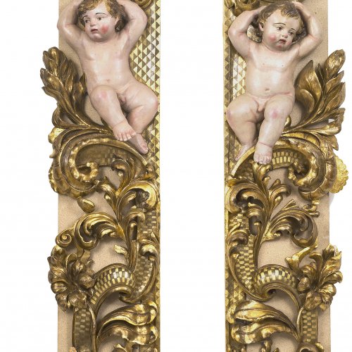Ein Paar Lisenen mit Voluten und Putti. Holz, Farbfassung.