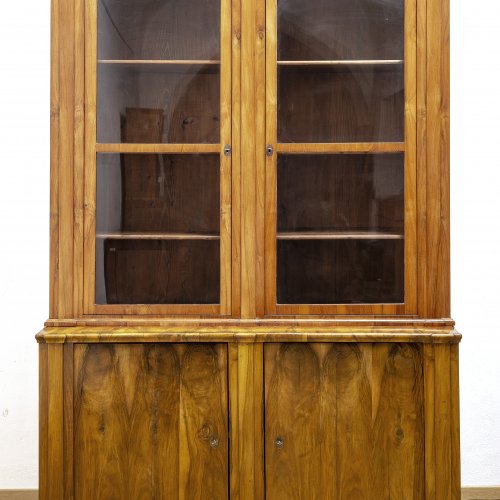 Bibliotheksvitrine. Süddeutsch, um 1830. Nussbaum furniert. 235 x 160 x 65. Zweitüriger Aufsatz.