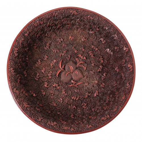 Teller. Japan, 19./20. Jh. Rotlack. Fledermäuse über Wellen, mittig eine Frucht.  H. 5,8 cm, ø 33 cm.