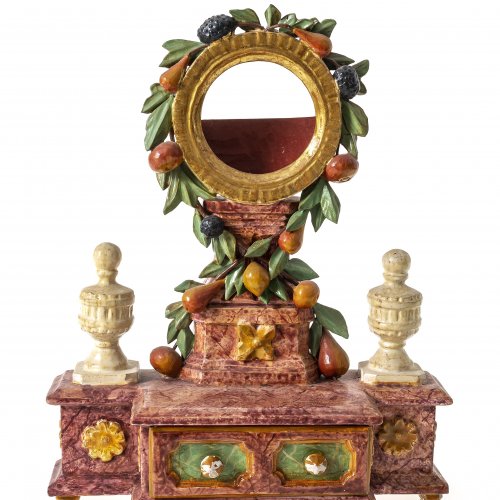 Taschenuhrenständer. Süddeutsch. Holz, geschnitzt, farbig gefasst und marmoriert, mit Früchten, Blättern und Schublade. Rest. H. 21,5 cm.