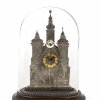 Kleine Tischuhr mit Glassturz, Kathedralenfassade, Weißmetall, H. 10,5 cm.
