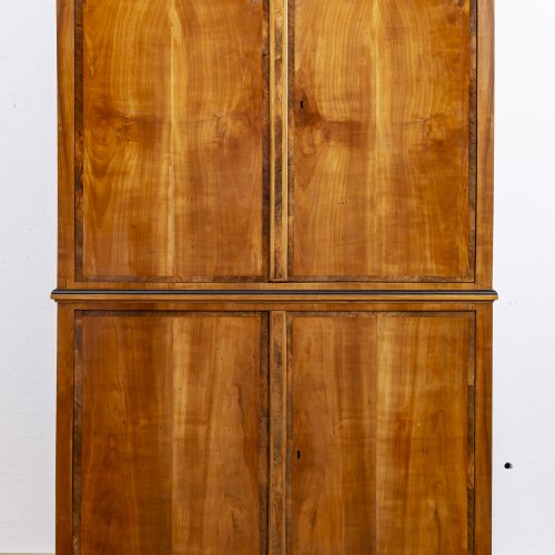 Aufsatzschrank. Süddeutsch, Franken um 1820. Kirschbaum furniert. Innen Nussbaum furniert. 215 x 132 x 62 cm.