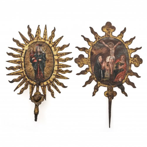 Zwei Votragestangenbekrönungen. Süddeutsch, 18. Jh. Madonna mit Kind und Kreuzigung mit Schmerzensmutter und Johannes, jeweils im Strahlenkranz. Öl/Blech. Alterungsspuren. H. 24-26 cm.